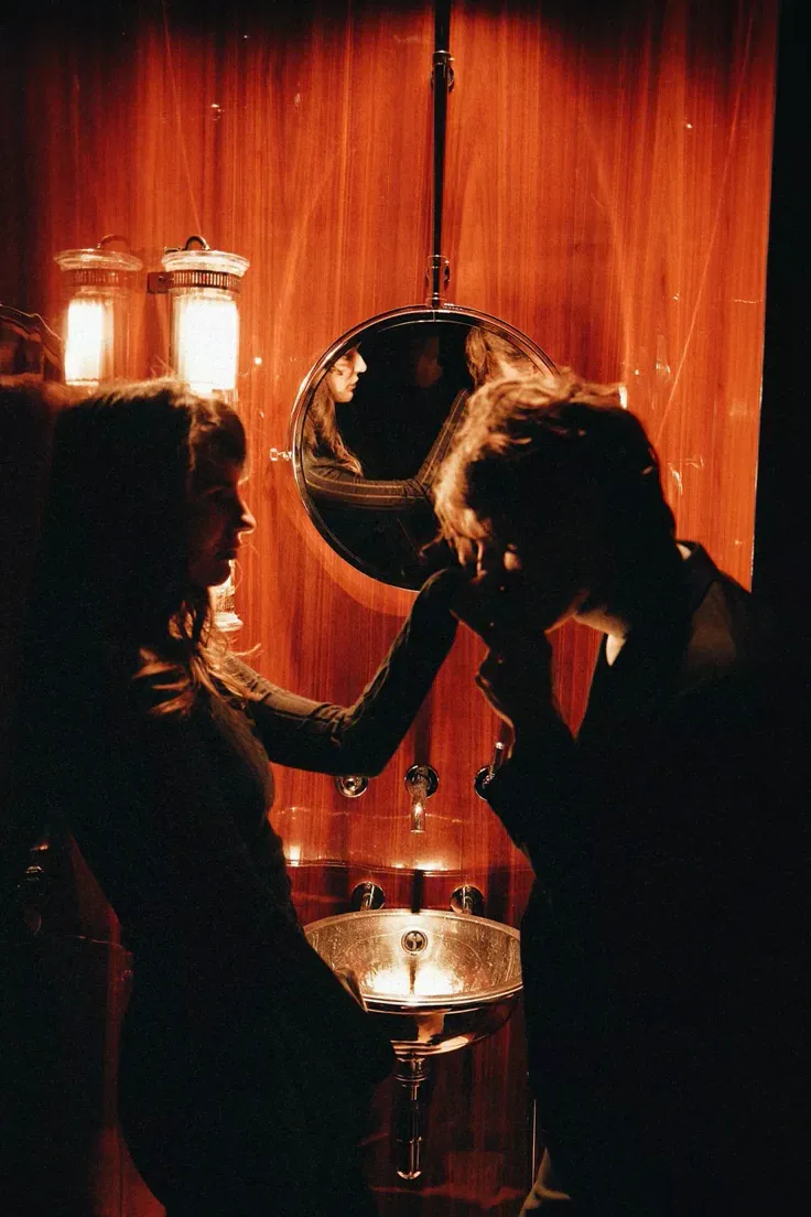 Two guests in candlelight before a mirror